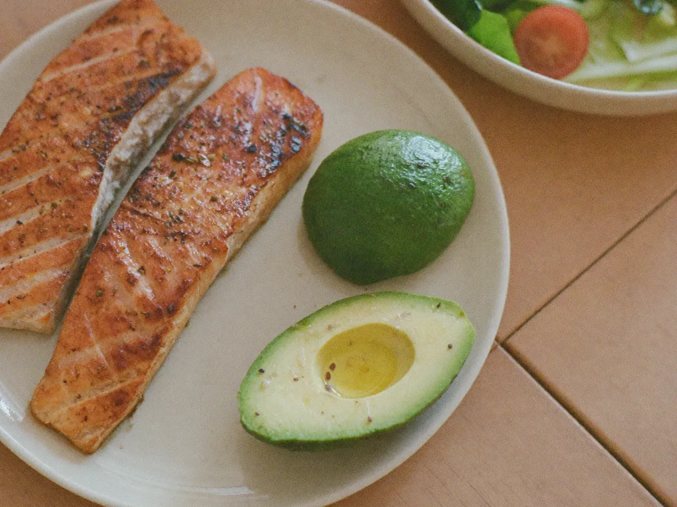 http://Plato%20equilibrado%20con%20proteína,%20verduras%20frescas%20y%20grasas%20saludables%20sobre%20una%20mesa%20luminosa%20de%20tonos%20cálidos.