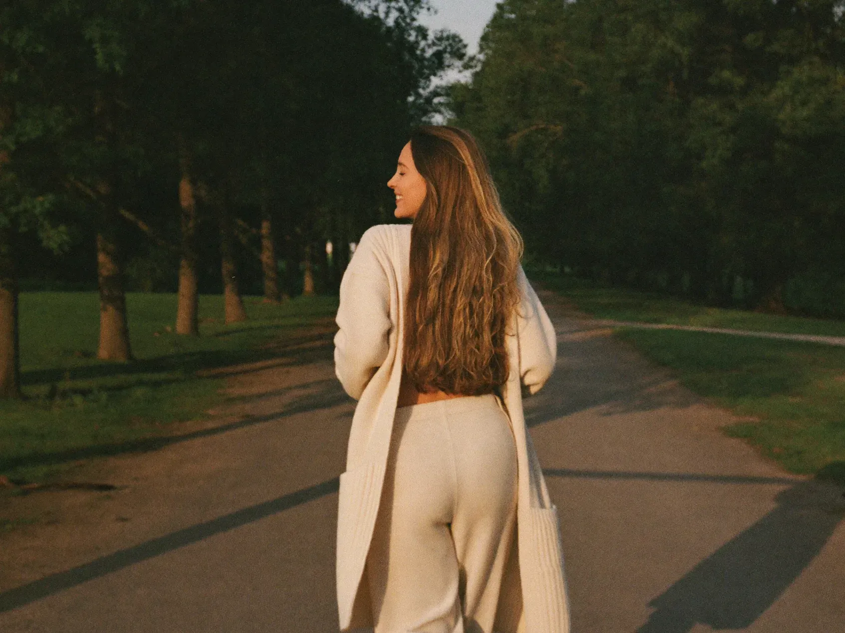 http://Mujer%20caminando%20al%20aire%20libre%20con%20luz%20cálida%20natural,%20en%20un%20momento%20de%20bienestar%20y%20calma.