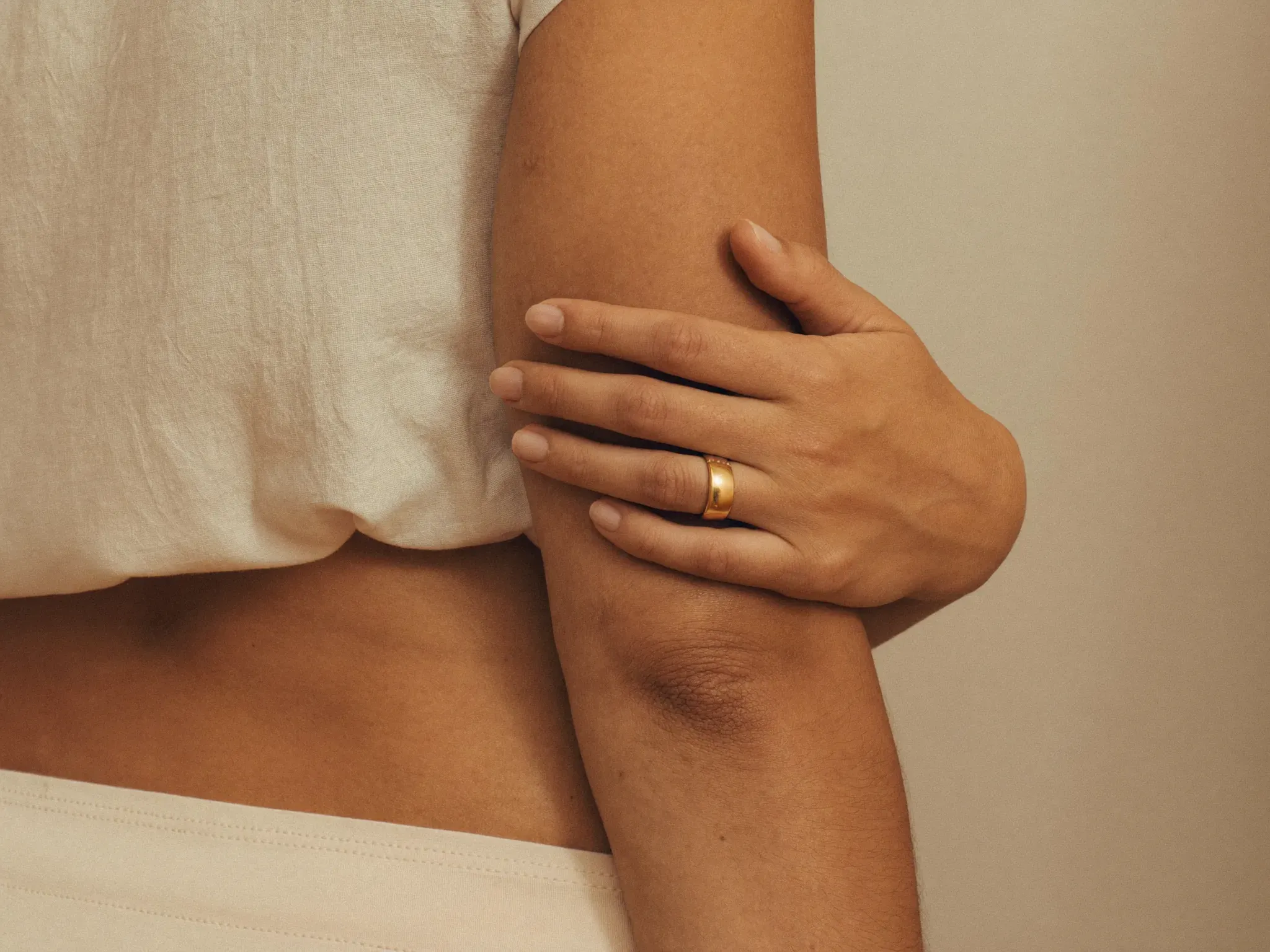 http://Mujer%20tocando%20suavemente%20su%20brazo%20firme%20y%20de%20piel%20suave,%20serena%20y%20confiada,%20con%20luz%20natural%20cálida.