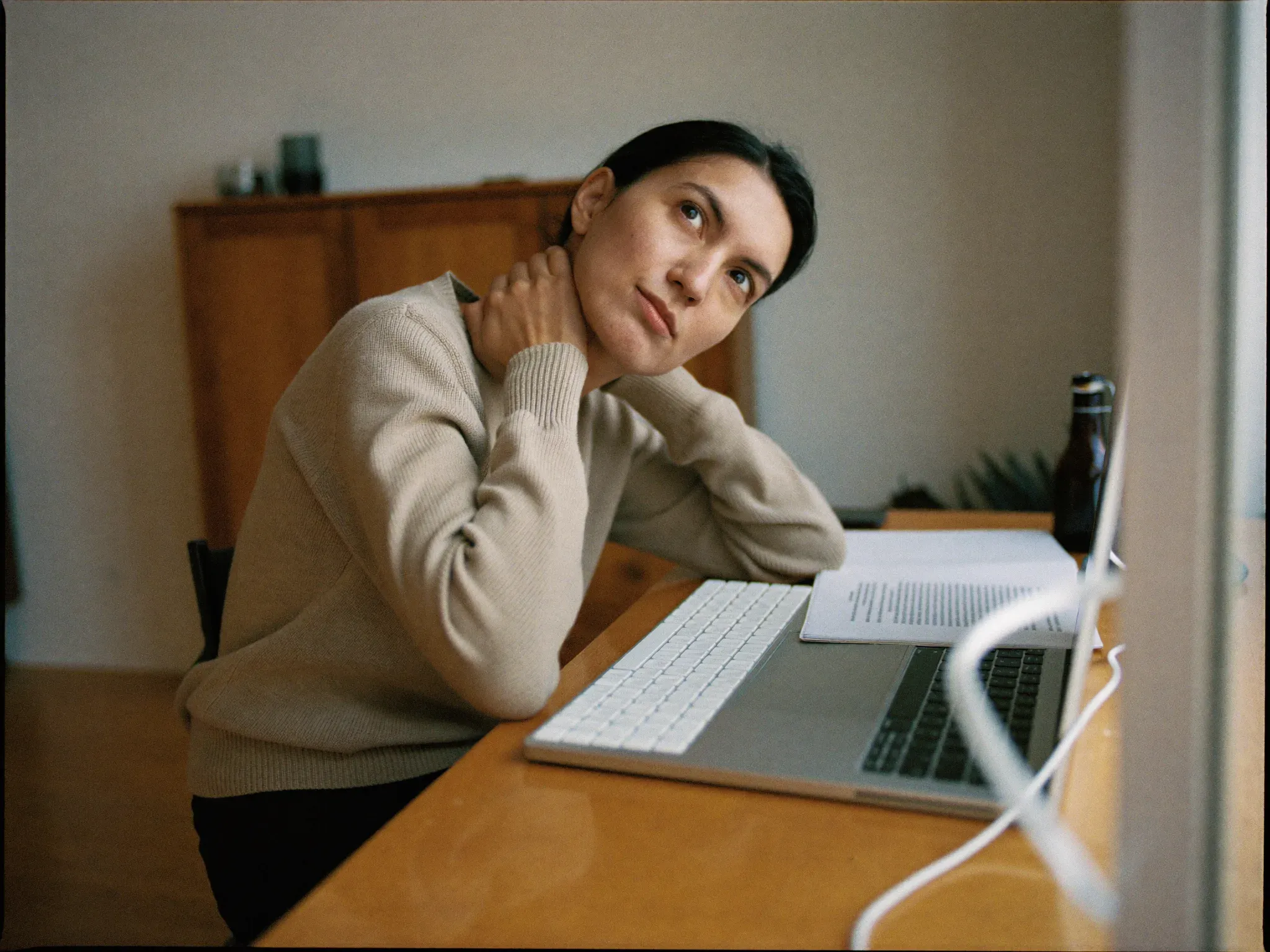 http://Mujer%20con%20gesto%20de%20cansancio%20llevándose%20la%20mano%20al%20cuello%20frente%20a%20su%20escritorio%20al%20final%20de%20la%20jornada.